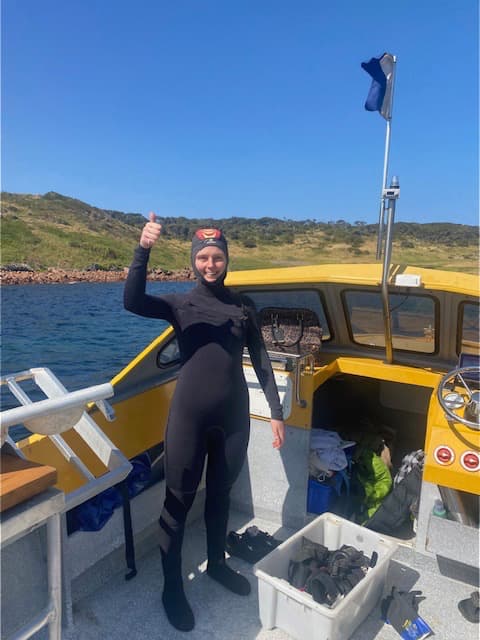 Young diver giving thumbs up on boat